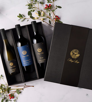 Three bottles of Stags' Leap wine in a black linen box with holiday garnish