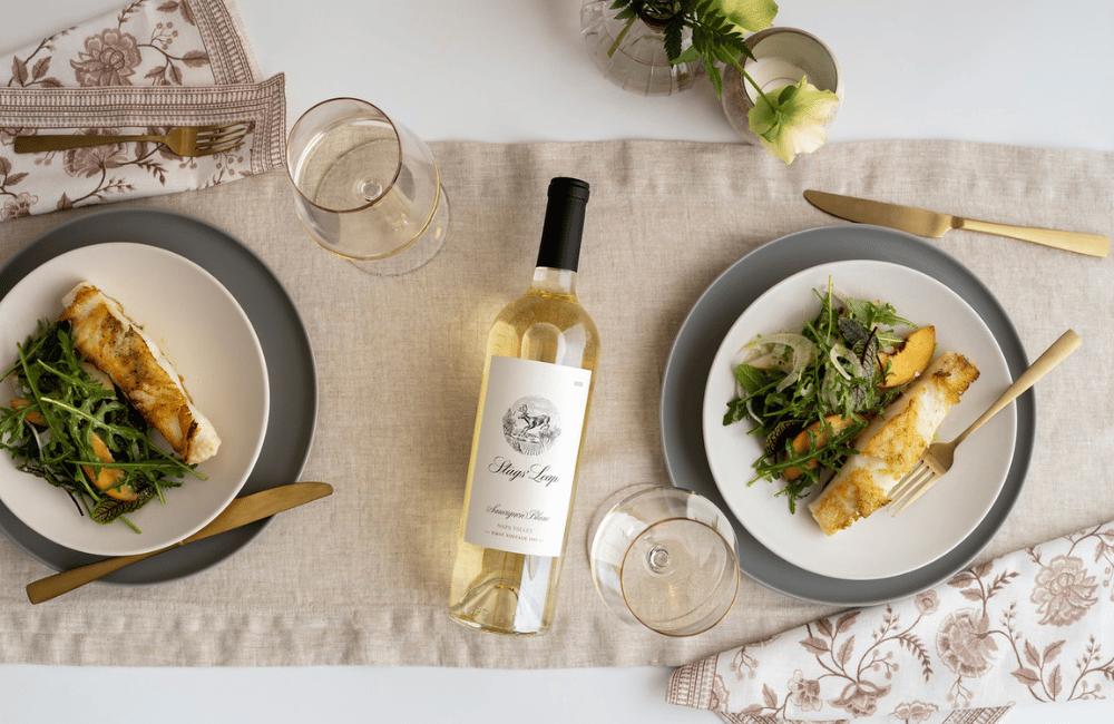 A bottle of Sauvignon Blanc on a table with grilled sea bass